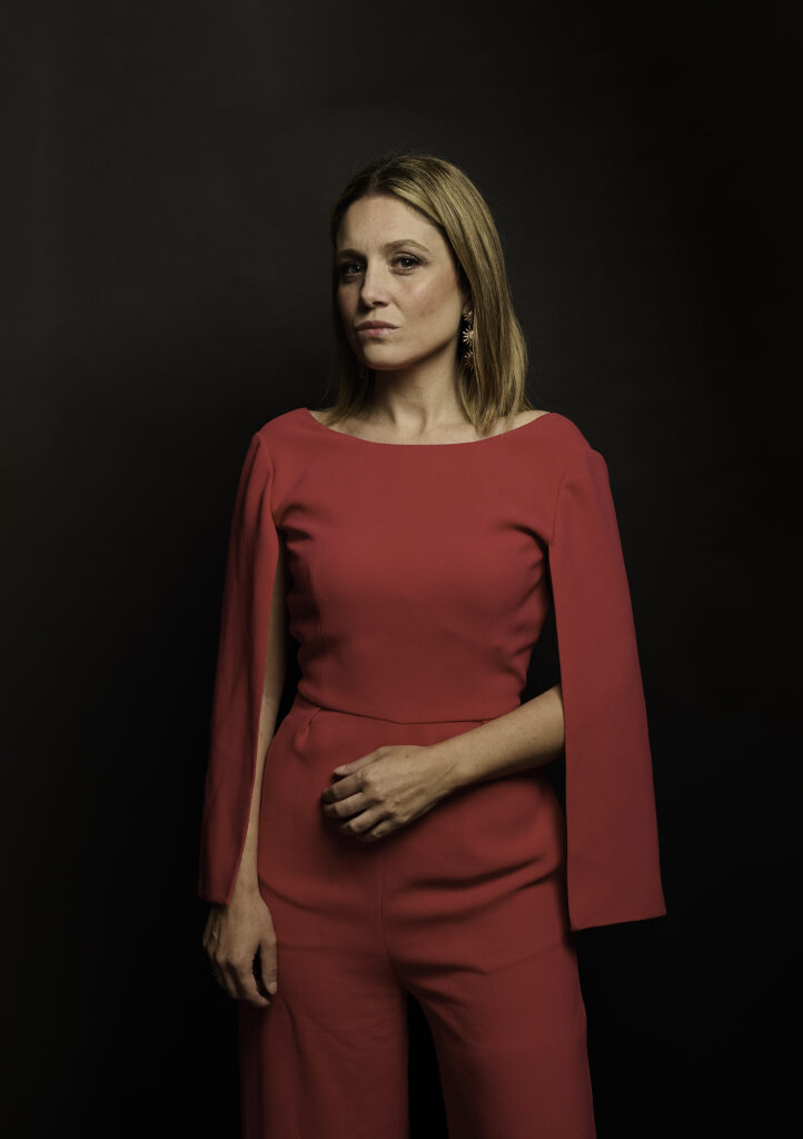 Chica joven posa para retrato fotográfico de pie con vestido rojo en estudio en Bilbao