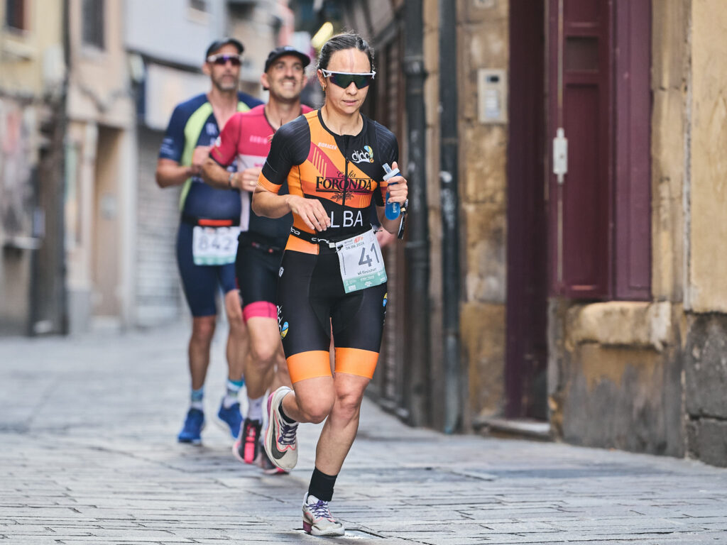 Mujer corriendo durante una carrera urbana con otros participantes